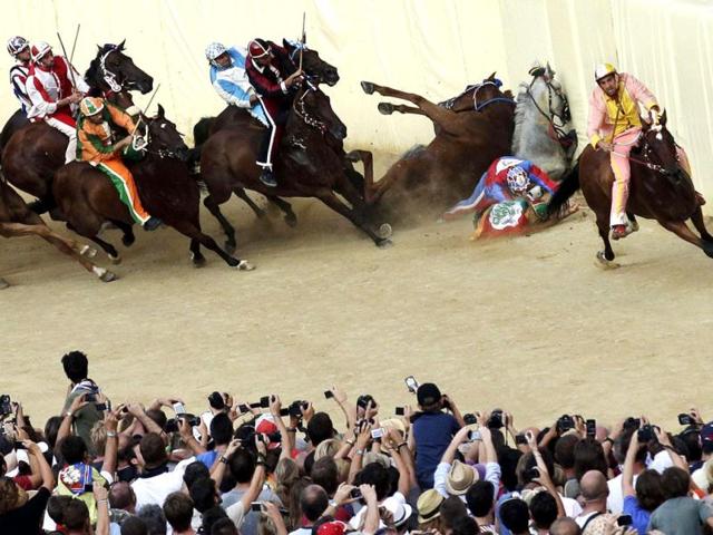 Riders fall as their horses crash during the Palio race in Siena. Almost without fail since the mid-1600s, 10 riders compete every year bareback around Siena's shell-shaped central square in a bid to win the Palio, a silk banner depicting the Madonna and child. Reuters