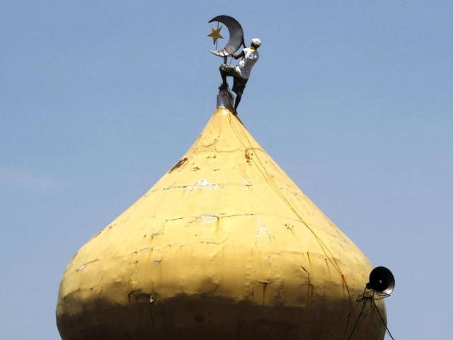 A worker cleans the crescent moon and star symbol on a dome of a mosque ahead of Eid ul-Fitr in Pasay city, Manila. (Reuters/Romeo Ranoco)
