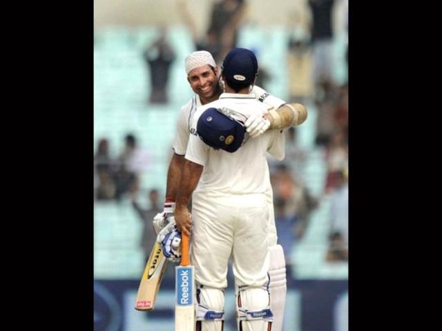 Captain Mahendra Singh Dhoni congratulates VVS Laxman for scoring a century (100 runs) during the second day of the second Test match between Indian and West Indies at the Eden Gardens in Kolkata. AFP photo/Dibyangshu Sarkar