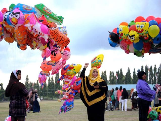 An Indonesian Muslim woman holds a balloon during Eid ul-Fitr at Bajra Sandhi monument and park in Denpasar on Indonesia's resort island of Bali. (AFP/Sonny Tumbelaka)