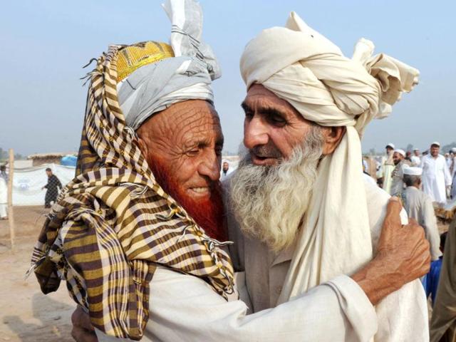 Pakistani internally displaced tribesmen, fleeing from military operations against Taliban militants in the Pakistani tribal region, hug after offering Eid ul-Fitr prayers at Jalozai, Pakistan's largest refugee camp. (AFP/ A. Majeed)