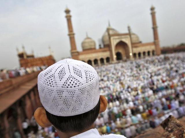 A boy sits on the balcony of the Jama Masjid while offering prayers on the occasion of Eid-al-Fitr in the old quarters of Delhi . Reuters/Mansi Thapliyal