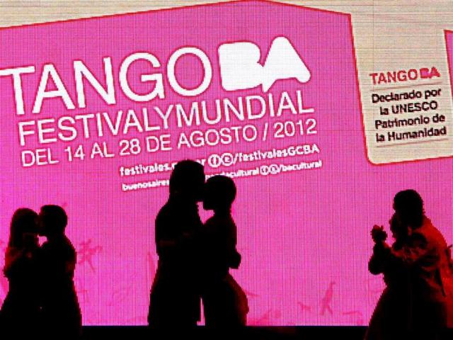 Couples are silhouetted as they dance in front of a screen with the Tango Festival logo during the Salon style Tango World Championship qualifiers in Buenos Aires. Reuters/Marcos Brindicci