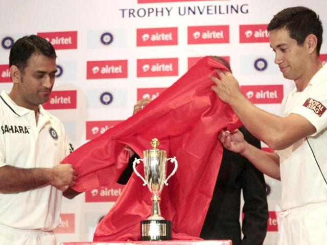 Team India captain Mahendra Singh Dhoni, left, and New Zealand captain Ross Taylor, right, unveil the trophy for their test and T20 cricket series in Hyderabad. (AP Photo/Mahesh Kumar A.)