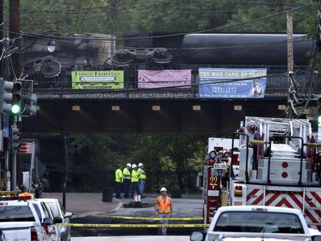 Officials stand underneath a bridge where part of a CSX freight train derailed overnight in Ellicott City, Md. (AP Photo/Patrick Semansky)