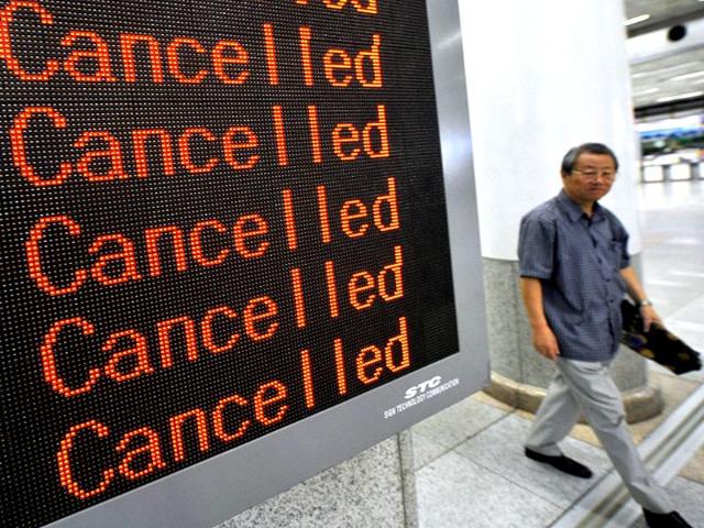 A man walks past an airport board announcing that all flights are cancelled following major typhoon Bolaven at Seoul domestic airport. AFP/Jung Yeon-Je