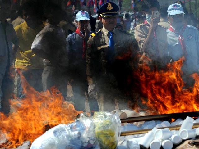 A Cambodian police looks at the flame and smoke from burning drugs during a destruction ceremony in Phnom Penh. Cambodian authorities burned more than one ton of drugs. AFP/Tang Chhin Sothy
