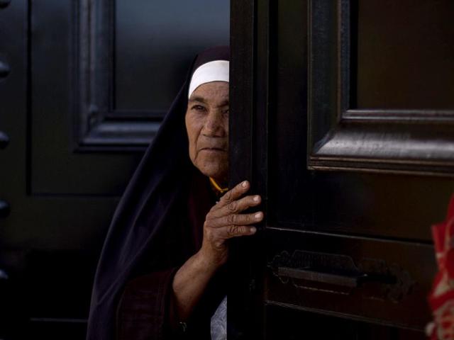 A catholic nun, of the Order of Saint Clare, peers from the door in Nueva Jerusalen, Mexico. AP/Alexandre Meneghini