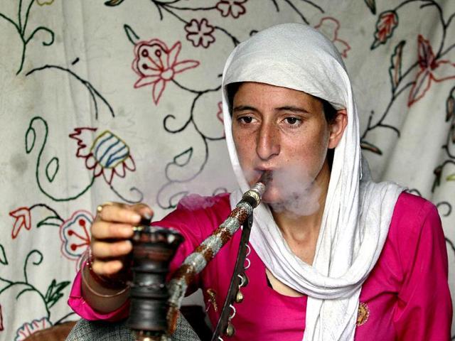 A Kashmiri woman smokes a pipe inside her shelter at a slum in Srinagar. Reuters/Fayaz Kabli