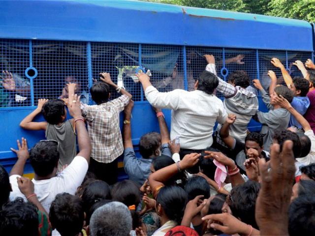 Relatives hang by the police vehicle as convicts are being taken to jail from the court after the pronouncement of the verdict on Naroda Patiya massacre in Ahmedabad. PTI Photo