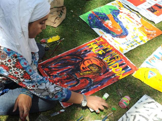 Kashmir University students paint during a protest organised by the Association of Parents of Disappeared People. AFP/Rouf Bhat