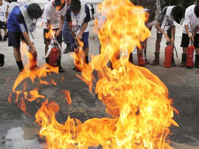 Junior high school students learn how to use fire extinguishers during a disaster drill in Tokyo to mark the Great Kanto Earthquake that hit the Tokyo metropolitan area in 1923. AP Photo/Itsuo Inouye