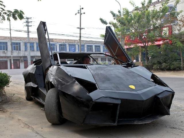 A friend of Wang Jian sits in a self-made replica of a Lamborghini Reventon in Suqian, Jiangsu province. Wang, a young Chinese farmer who worked at a garage for more than a decade, built the replica of a Lamborghini Reventon with a second-hand Nissan and Santana. (Reuters/Xihao)
