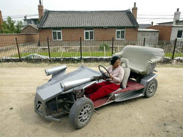 Zhang Jinduo's wife tries on a self-made racing car on the outskirts of Shenyang, Liaoning province. Zhang, the 53-year-old local farmer made the racing car with the help of his son who is a car mechanic. The car is equipped with a rear-mounted motorcycle engine and can achieve 60-80 km per hour, according to local media. (Reuters/Stringer)