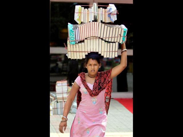 A woman carries books during the inauguration of the 18th Delhi Book Fair at Pragati Maidan in New Delhi. PTI Photo