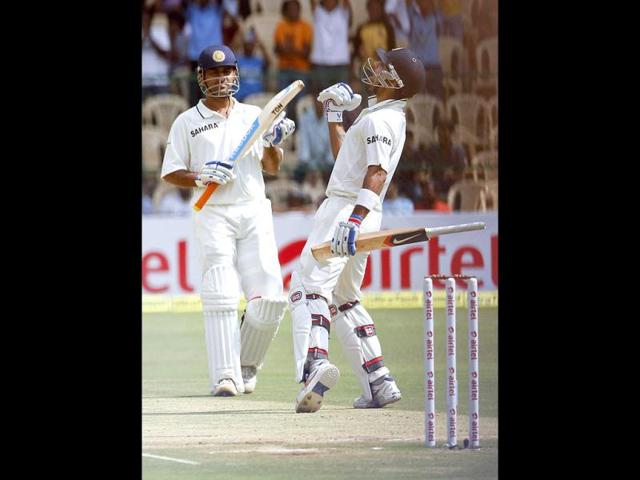 Virat Kohli (R) celebrates scoring a century as captain Mahendra Singh Dhoni watches during the third day of their second test cricket match against New Zealand in Bangalore. Reuters/Vivek Prakash