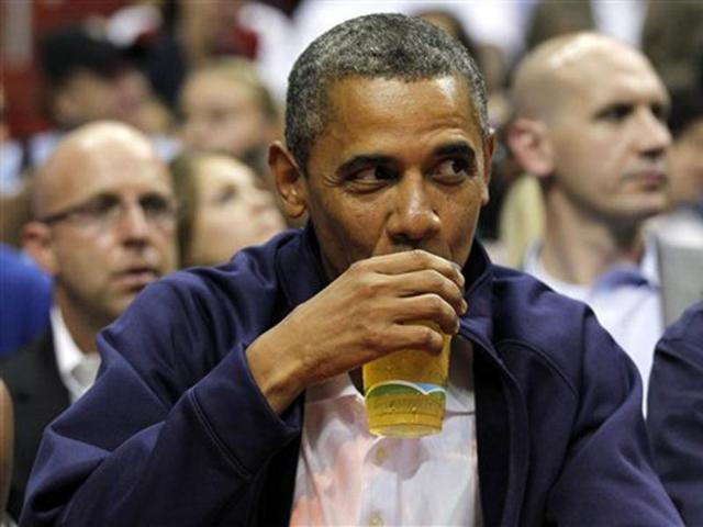 US President Barack Obama sips his beer as he watches Team USA and Brazil during the first half of an Olympic men's exhibition basketball game, in Washington. AP Photo/Alex Brandon, File