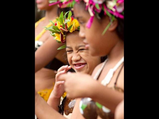 Children perform traditional dances during a visit by US Secretary of State Hillary Clinton at the Avarua markets in Rarotonga, Cook Islands. AFP PHOTO / Marty Melville