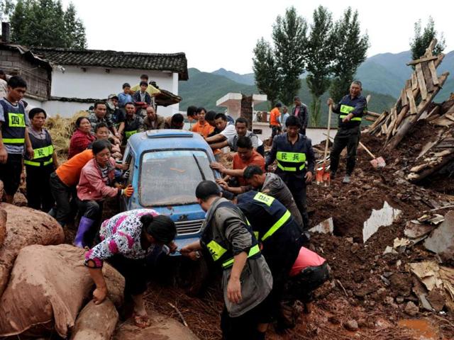 Rescuers help locals move a trapped car to safer areas after heavy rainfall hit Liangshan, Sichuan province. Reuters/China Daily