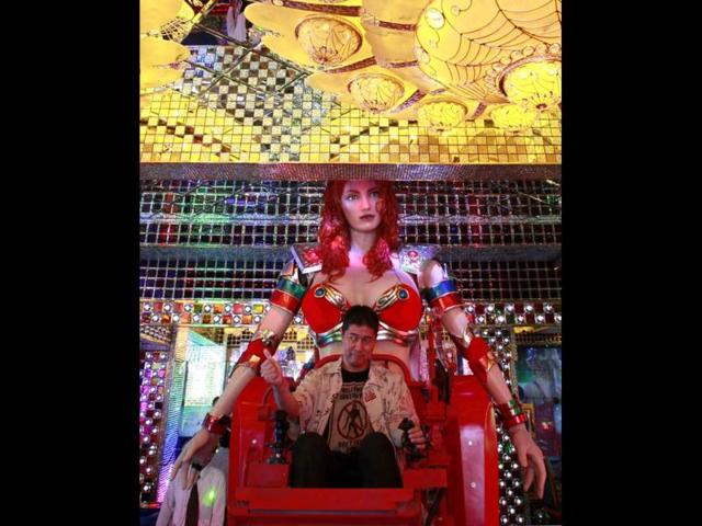 A customer gives a thumbs-up as he is seated on a custom-made female robot at the newly opened Robot Restaurant in Kabukich. Reuters Photo