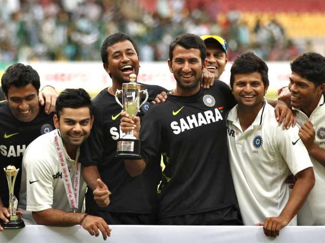 Members of Indian cricket team, from left, Ravichandran Ashwin, Virat Kohli, Pragyan Ojha, Cheteshwar Pujara, Suresh Raina and Umesh Yadav pose with the winners trophy after their win over New Zealand on the fourth day of their second cricket test match in Bangalore. (AP Photo/Aijaz Rahi)