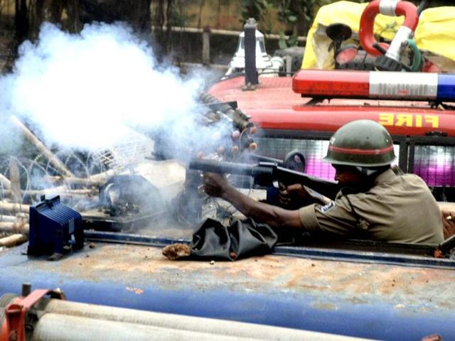 A policeman fires a tear-gas shell on Congress workers during a mass rally in Bhubaneswar. Dozens were injured as police fired teargas and charged crowds during a Congress party rally demonstrating against the state government.(PTI Photo)