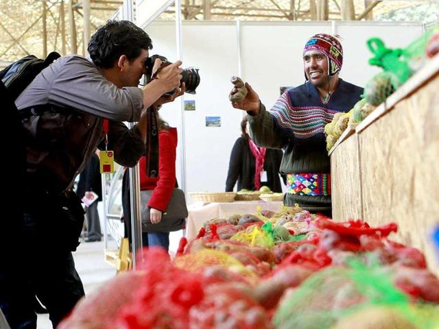 A farmer shows a potato to a photographer during the Mistura gastronomic fair in Lima. Reuters Photo