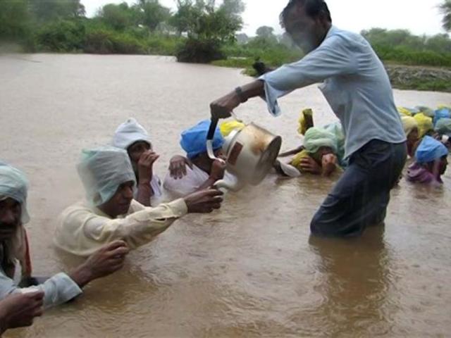 A villager serves tea to protestors standing in water during the ‘Jal Satyagraha’ or ‘insistence on truth by water’ at Ghogal village, in Khandwa area in Madhya Pradesh. AP photo