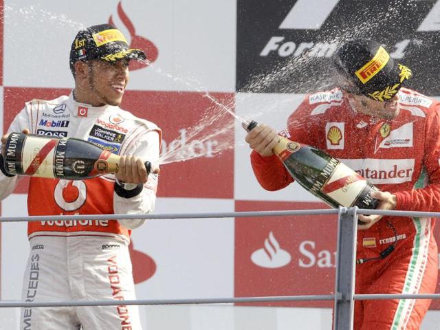 McLaren Mercedes driver Lewis Hamilton, left, of Britain, celebrates with third placed Ferrari driver Fernando Alonso, of Spain, after winning the Italian Formula One GP, at the Monza racetrack, in Monza, Italy. AP Photo/Antonio Calanni