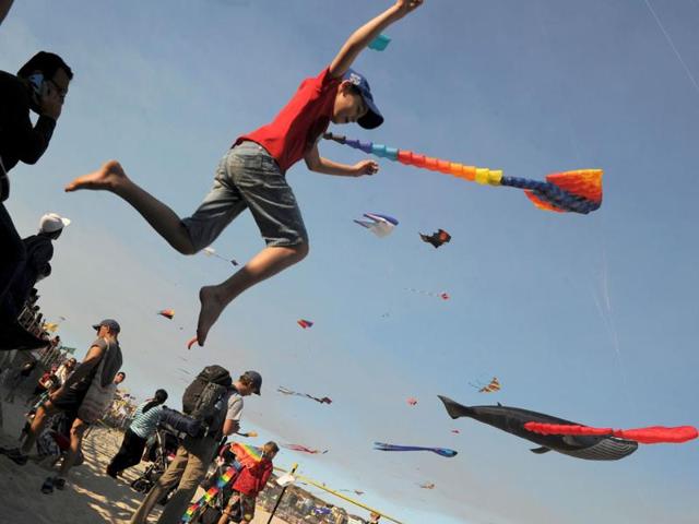 A-boy-jumps-from-the-walkway-at-the-Sydney-s-Bondi-Beach-while-giant-kites-fly-in-the-background-during-the-annual-Festival-of-the-Winds-AFP-photo-Romeo-Gacad A-boy-jumps-from-the-walkway-at-the-Sydney-s-Bondi-Beach-while-giant-kites-fly-in-the-background-during-the-annual-Festival-of-the-Winds-AFP-photo-Romeo-Gacad