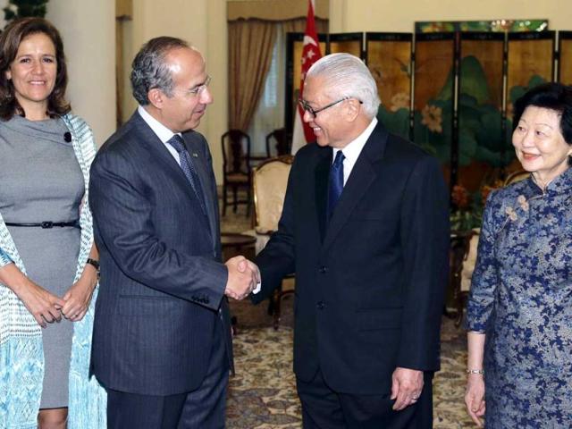 Mexico's President Felipe Calderon (2nd L) shakes hands with his Singaporean counterpart Tony Tan before their meeting at the Istana presidential palace in Singapore. At their sides are Mexican First Lady Margarita Zavala (L) and Tan's wife Mary Chee. REUTERS/Tim Chong