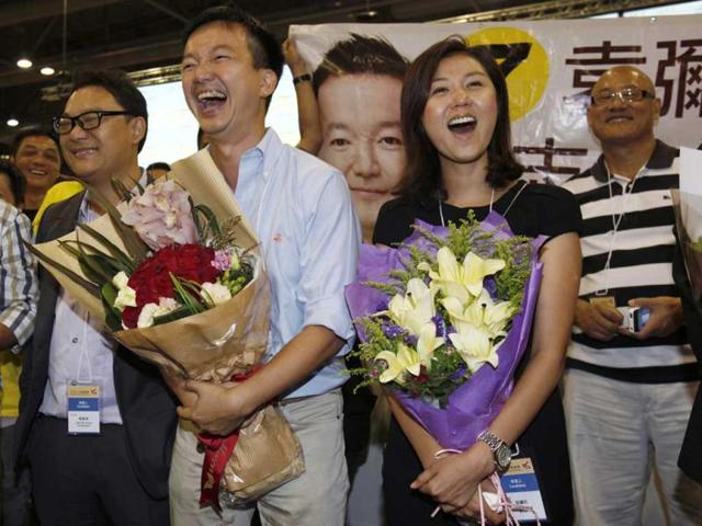 Former Miss Hong Kong contestant and Legislative Council election candidate Erica Yuen (2nd R) and her election partner, former radio disc jockey Ray Chan (2nd L) from the pro-democracy People Power react at the central ballot counting centre in Hong Kong. Chan won in the election and Yuen lost. Political allies of Hong Kong's new Beijing-backed leader performed solidly in city-wide legislative council elections despite recent controversies over contentious China-linked policies, potentially easing pressure on his administration. REUTERS/Bobby Yip