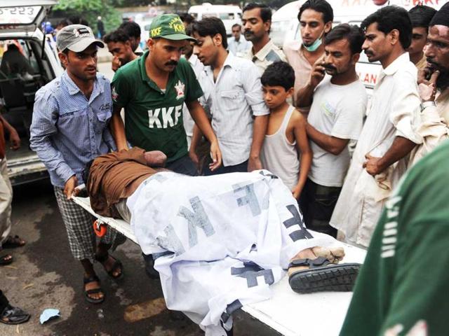 Pakistani rescuers move the dead body of a garment labourer who was killed after fire erupted at a factory in Karachi. (AFP/Rizwan Tabassum)