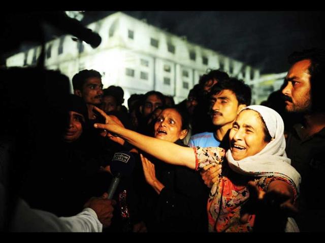 A Pakistani woman mourns the death of her relatives in front of the garment factory in Karachi. (AFP/Asif Hassan)