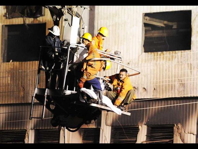 Pakistani rescuers shift the dead body of a worker after a garment factory was engulfed in a fire in Karachi. (AFP/Asif Hassan)
