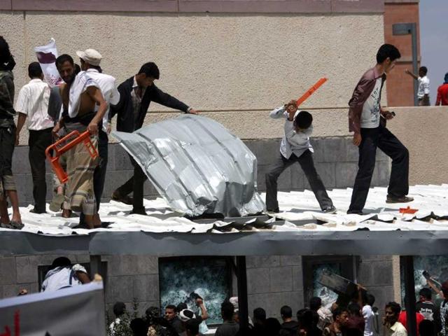 Yemeni protesters try to break through the US embassy in Sanaa during a protest over a film mocking Islam. Yemeni forces managed to drive out angry protesters who stormed the embassy in the Yemeni capital with police firing warning shots to disperse thousands of people as they approached the main gate of the mission. AFP PHOTO/MOHAMMED HUWAIS