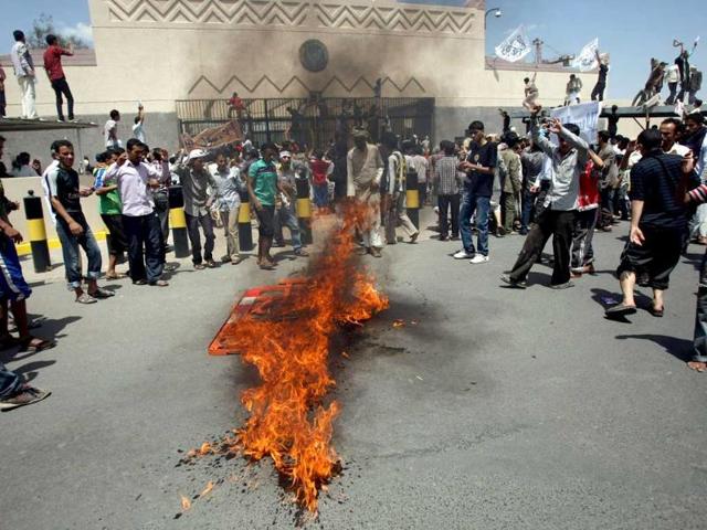 Yemeni protesters gather around fire during a demonstration outside the US embassy in Sanaa over a film mocking Islam. Yemeni forces managed to drive out angry protesters who stormed the embassy in the Yemeni capital with police firing warning shots to disperse thousands of people as they approached the main gate of the mission. AFP PHOTO/MOHAMMED HUWA