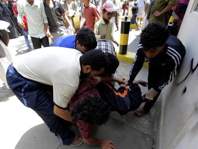 Medics carrying a protester injured during a demonstration at the US embassy in Sanaa. Reuters/Mohamed al-Sayaghi
