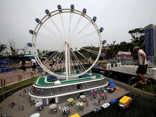 Legoland Parks' project coordinator Stefan Bentivoglio of Germany makes fine adjustments to a lego model of Singapore's Flyer and central business district during a media preview of Legoland Malaysia in Johor Bahru. Reuters/Edgar Su