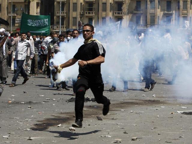 A protester picks up a tear gas canister to throw it back to the police during a demonstration, condemning a US-made film which they say insults the Prophet Mohammad, near the US embassy in Cairo. (Reuters/Asmaa Waguih)