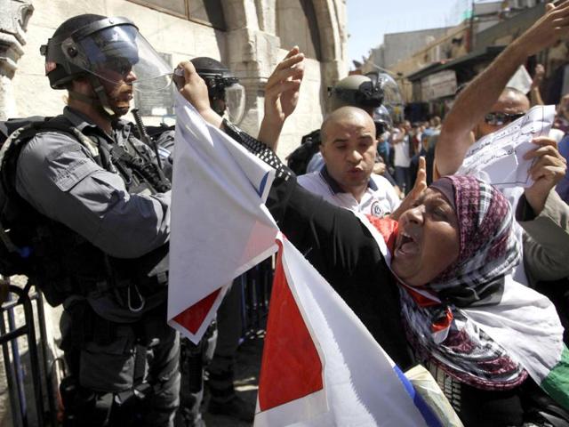 A Palestinian protester shouts as she passes Israeli border policemen (L) during a demonstration denouncing a US-made film that mocks the Prophet Mohammed, in Jerusalem's Old City. (Reuters/Ammar Awad)