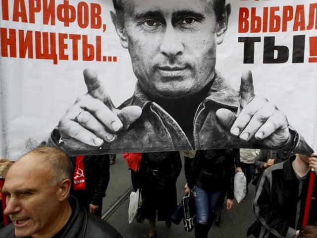 People hold a banner, displaying an image of Russia's President Vladimir Putin, during the "March of Millions" protest rally, held by opposition supporters in St. Petersburg. The banner reads "Prices and tariffs increase, poverty. Friend, that was you who chose it all!". Reuters/Alexander Demianchuk