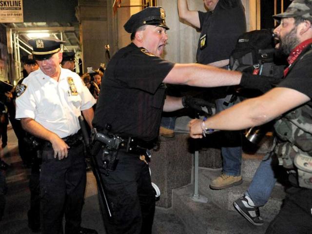 A group of people associated with the Occupy movement are pushed down the sidewalk up Broadway away from Trinity Church in New York. About 300 people observing the one-year anniversary of Occupy Wall Street ended a march to a small concrete park in New York's Lower Manhattan that served as headquarters for the protest movement and was its birthplace. AP photo