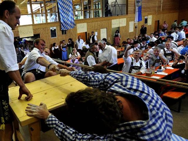 Finger wrestlers compete in the German Finger Wrestling Championship in Warngau, southern Germany. More than 150 men taking part in the traditional Bavarian event try to pull their opponent over the table by using their fingers and a rubber strap only. (AFP photo/ Frank Leonhardt) 