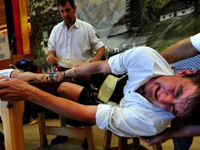 Finger wrestlers compete in the German Finger Wrestling Championship in Warngau, southern Germany. More than 150 men taking part in the traditional Bavarian event try to pull their opponent over the table by using their fingers and a rubber strap only. (AFP photo/ Frank Leonhardt) 