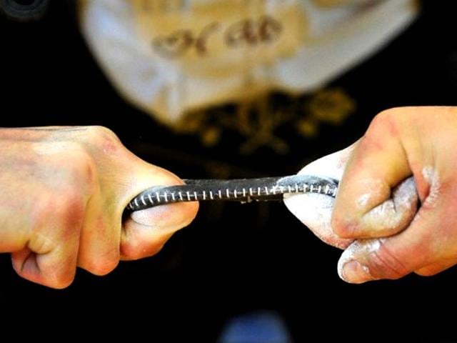 Finger wrestlers compete in the German Finger Wrestling Championship in Warngau, southern Germany. More than 150 men taking part in the traditional Bavarian event try to pull their opponent over the table by using their fingers and a rubber strap only. (AFP photo/ Frank Leonhardt) 
