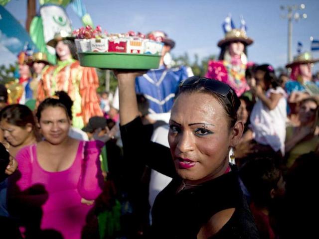 A transvestite sells cigarettes as residents spend the day at an amusement park set-up recently by the Sandinista government at the La Fe square in Managua, Nicaragua. AP photo