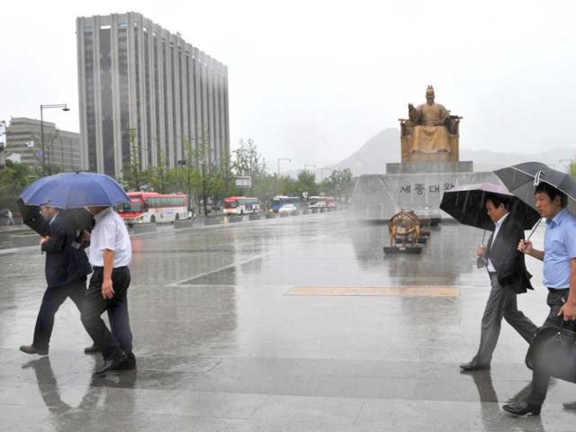 Pedestrians walk on the streets of downtown Seoul as the country redies for the arrival of Typhoon Sanba. The typhoon packing winds of 155 kilometres (97 miles) per hour, slammed into South Korea, bringing torrential rains across the country and shutting down flights and ferry services. AFP photo