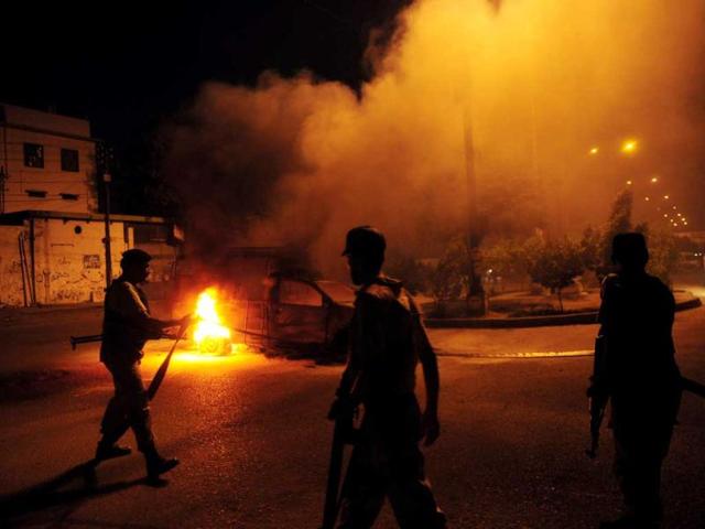 Pakistani paramilitary soldiers stand near a burning police van during a protest rally organised by Pakistani Shiite Muslims against an American produced film mocking Islam. AFP photo