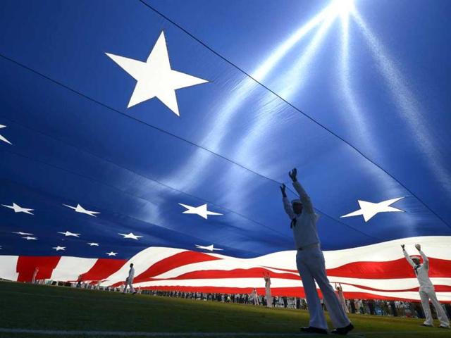 US Armed forces hold a giant American Flag on the field at the start of the San Diego Chargers against the Tennessee Titans on at Qualcomm Stadium in San Diego, California. AFP photo